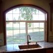 Custom radius window trim over kitchen window.